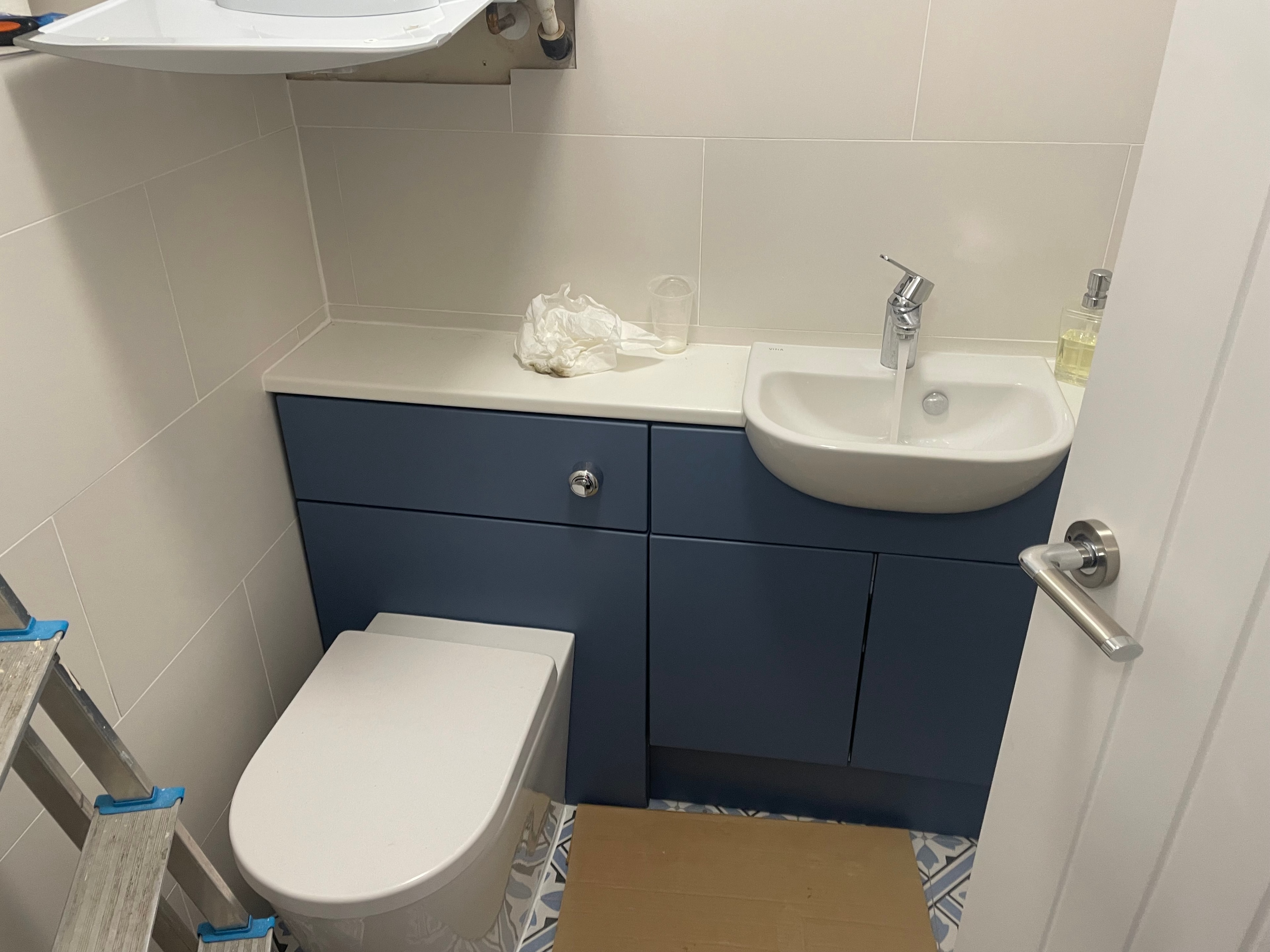 Modern bathroom with navy vanity unit and wall-hung toilet
